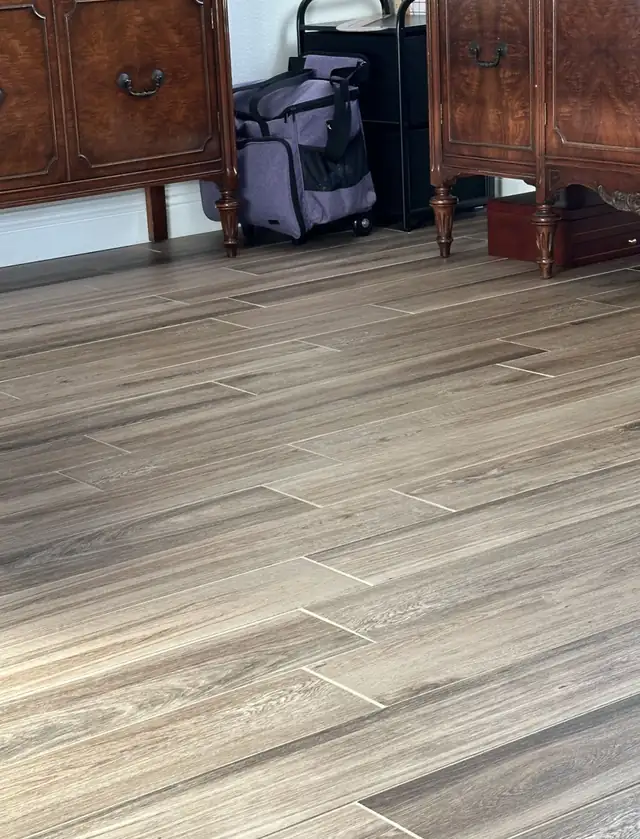Gray-brown wood-look porcelain plank tile floor in a living and dining room